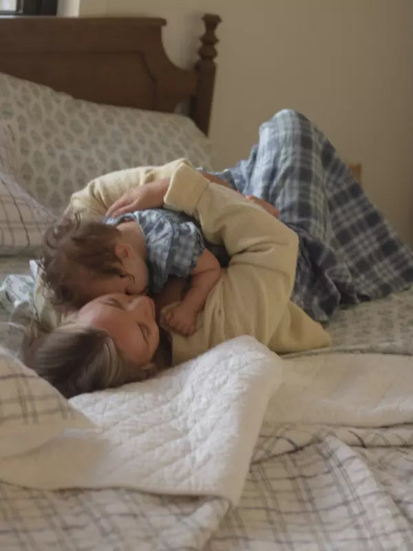 A mother and child sharing a quiet morning in bed